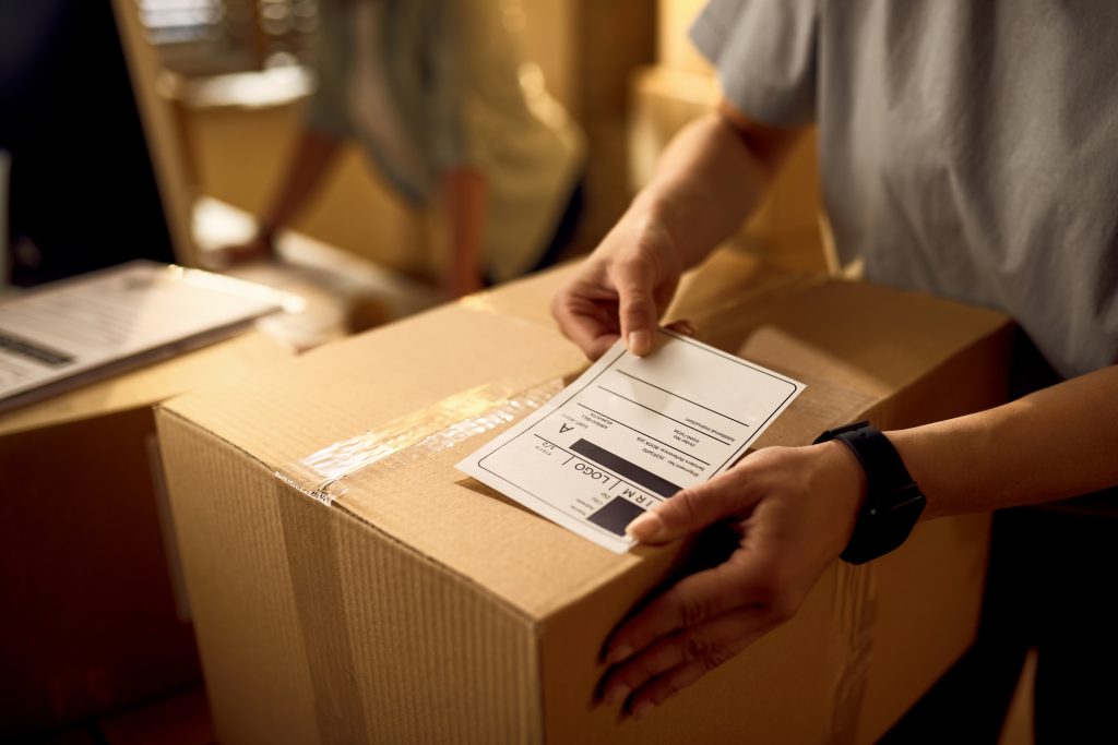 Person applying barcode label to box